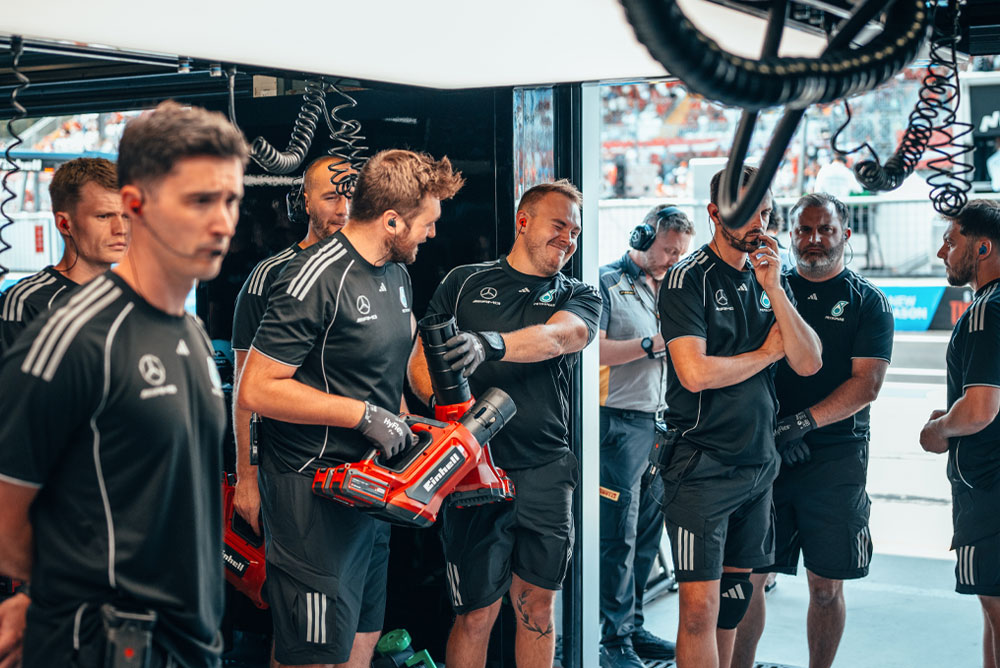 The Mercedes-AMG PETRONAS Formula One Team is in the garage. Two team members are holding red cordless blowers from Einhell, preparing for the next action.