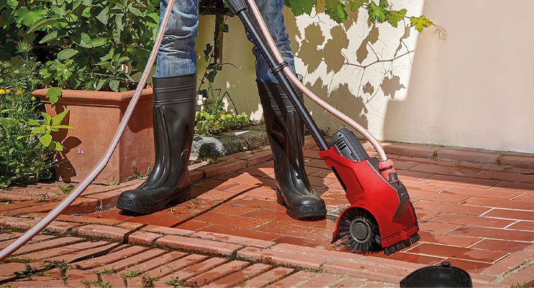 Person cleaning floor with a surface grout cleaner