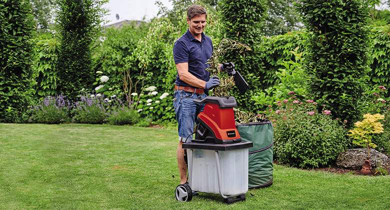 a man puts bush in a shredder