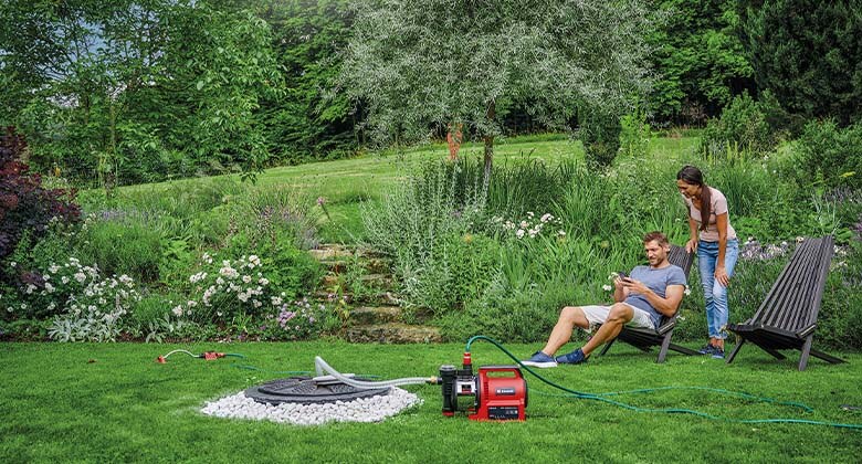 a man shows a woman something on a cell phone while the water pump is running